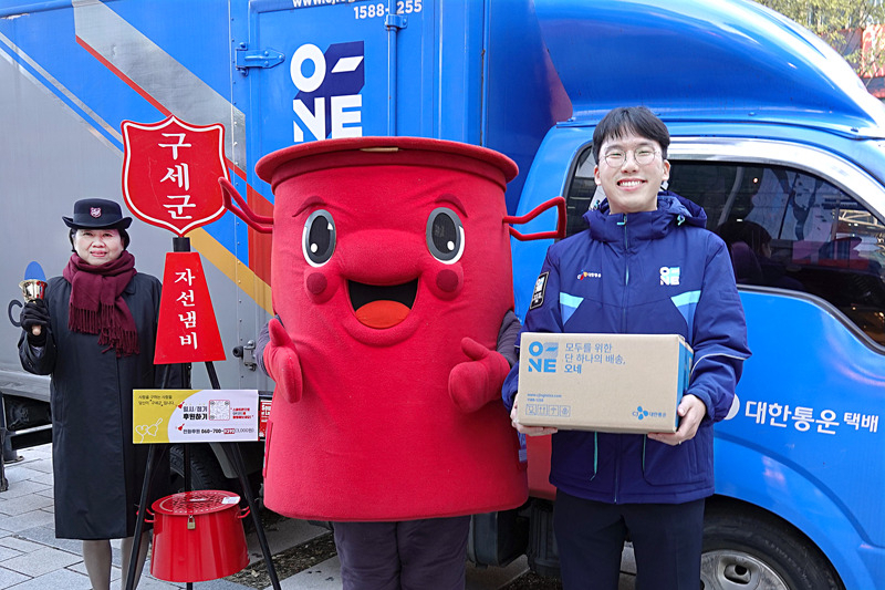 CJ대한통운 오네(O-NE) 배송차량 앞에서 CJ대한통운 직원과 구세군 사관, 구세군 캐릭터 따끈이가 10주년 기념촬영을 하고 있다. [CJ대한통운 제공]