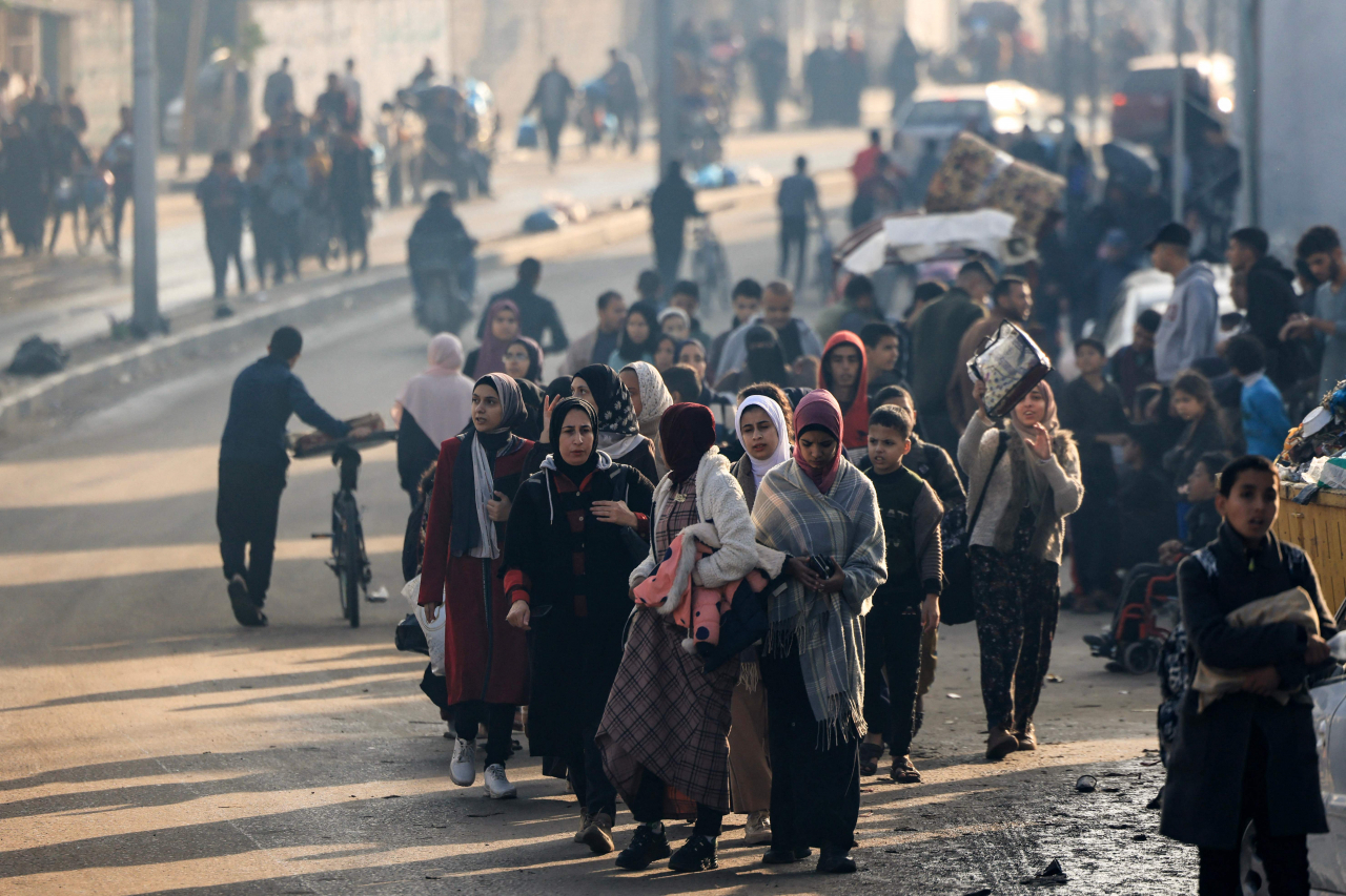 Palestinians walk toward safer areas following the resumption of Israeli strikes on Rafah in the southern Gaza Strip on Friday, after the expiration of a seven-day truce between Israel and Hamas militants. A temporary truce between Israel and Hamas expired on Friday, with the Israeli army saying combat operations had resumed, accusing Hamas of violating the operational pause. (AFP)
