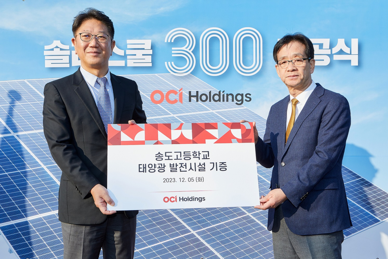 5일 인천 송도고에서 열린 솔라스쿨 준공식에서 성광현(왼쪽) OCI홀딩스 전무와 이상원 송도고등학교 교장이 함께 기념촬영을 하고 있다. [OCI홀딩스 제공]
