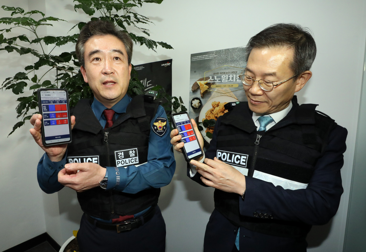 윤희근 경찰청장과 이종호 과학기술정보통신부 장관이 6일 오후 서울 도봉구 한 건물에서 발생한 모의 납치 사건의 신고자를 구조하기 위해 긴급구조 정밀측위 탐색 기술 시연을 해보고 있다. 구조 요청자가 신고를 하면 어깨에 장착된 와이파이 송신기를 통해 112 모바일폰에 연결돼 신고자 위치를 빠르게 확인할 수 있는 시스템이다. [연합]