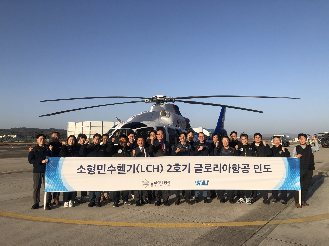 박진석(오른쪽 일곱번째부터) 한국항공우주산업(KAI) 회전익사업관리실장과 신대현 글로리아항공 대표이사 등이 소형민수헬기(LCH) 양산 2호기 앞에서 기념촬영을 하고 있다. [KAI 제공]
