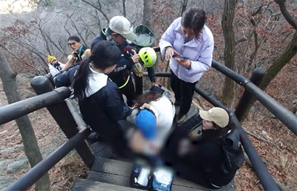 지난달 24일 북한산 등산 중 쓰러진 50대에게 응급처치를 하고 있는 간호사들. [SBS 방송화면 캡처]