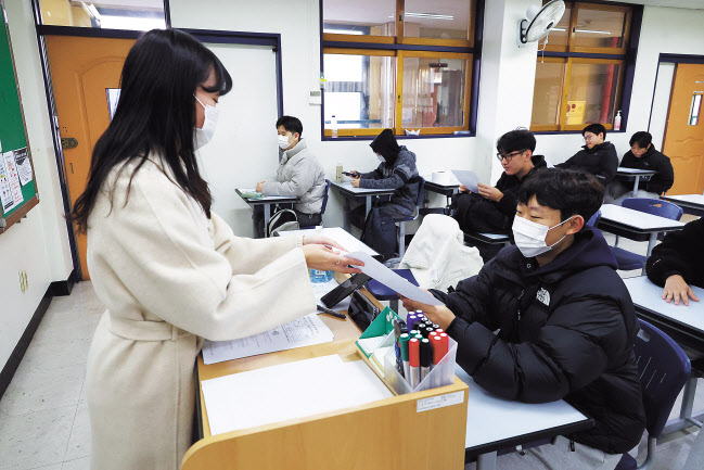 2024학년도 대학수학능력시험 성적표 배부일인 8일 오전 서울 종로구 경복고에서 3학년 학생이 교사로부터 성적표를 받고 있다. [사진공동취재단]