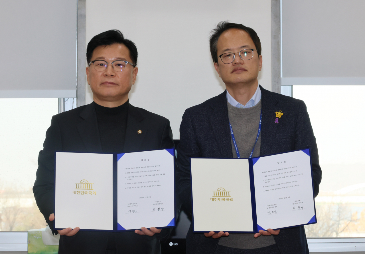 이양수 국민의힘 원내수석 부대표와 박주민 더불어민주당 원내수석부대표가 8일 국회에서 12월 임시회 관련 합의문을 들고 포즈를 취하고 있다. [연합]