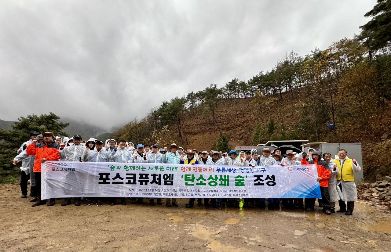 포스코퓨처엠은 기후변화 대응 및 탄소중립 실천을 위해 오는 2030년까지 ‘탄소상쇄 숲’을 전국 사업장 인근에 조성해 연간 탄소 510t을 감축하기로 했다. 지난달 16일 전남 광양 공장 인근 계족산에서 임직원들이 관련 행사를 열고 기념촬영을 하고 있다. [포스코퓨처엠 제공]