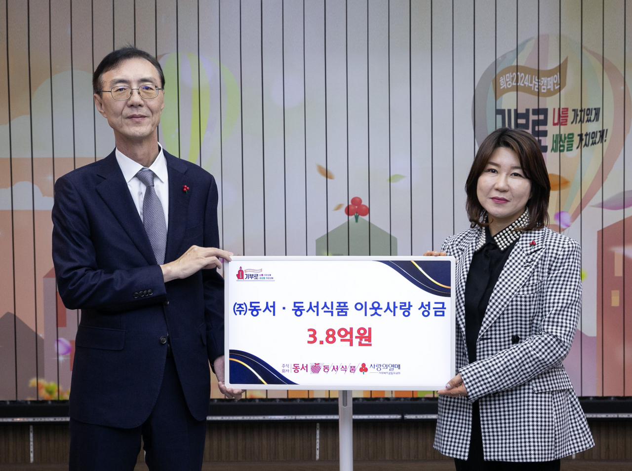 12일 서울 중구 사회복지공동모금회에서 열린 성금 기탁식에서 최상인 동서식품 홍보상무, 김경희 사회복지공동모금회 사회공헌본부장이 기념촬영을 하고 있다. [동서식품 제공]