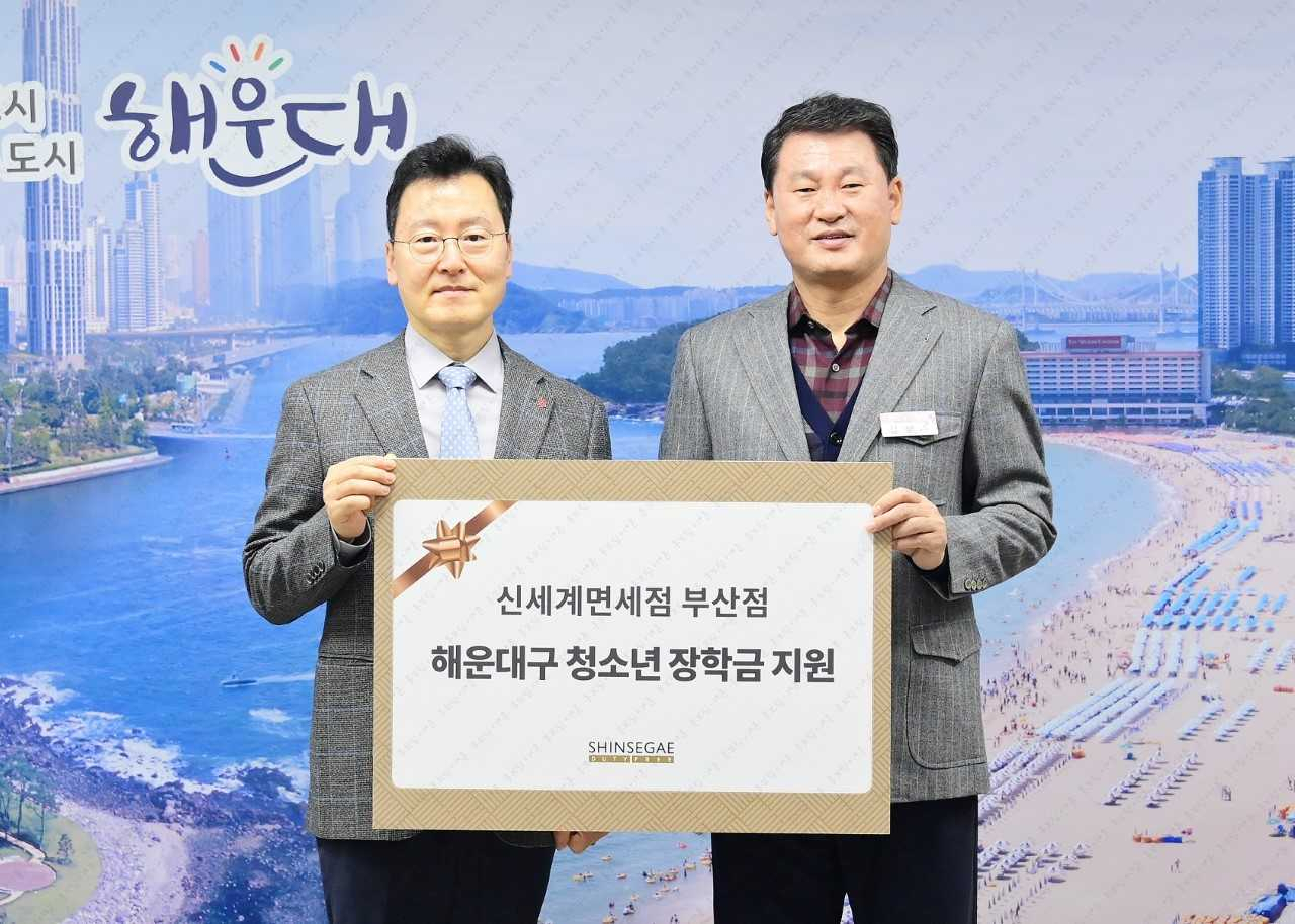 한세경 신세계면세점 부산점장과 김성수 해운대구청장이 지난 12일 부산 해운대구청에서 열린 해운대구 청소년 장학금 증정식에서 기념촬영을 하고 있다. [신세계면세점 제공]