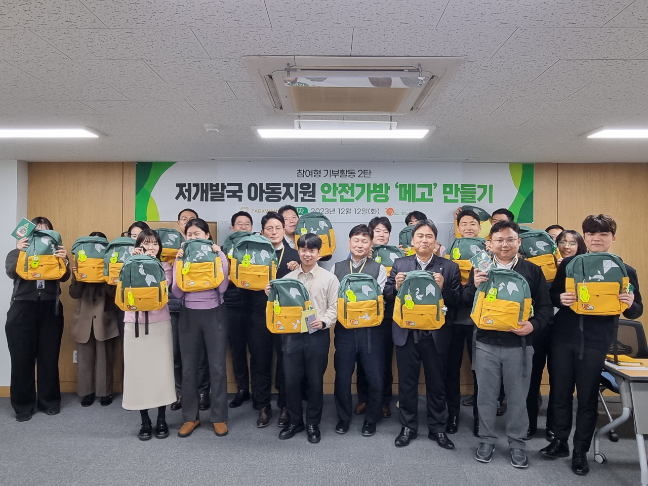 태광산업, 대한화섬 임직원들이 직접 만든 안전 가방 '메고'를 들고 기념촬영을 하고 있다. [태광산업 제공]