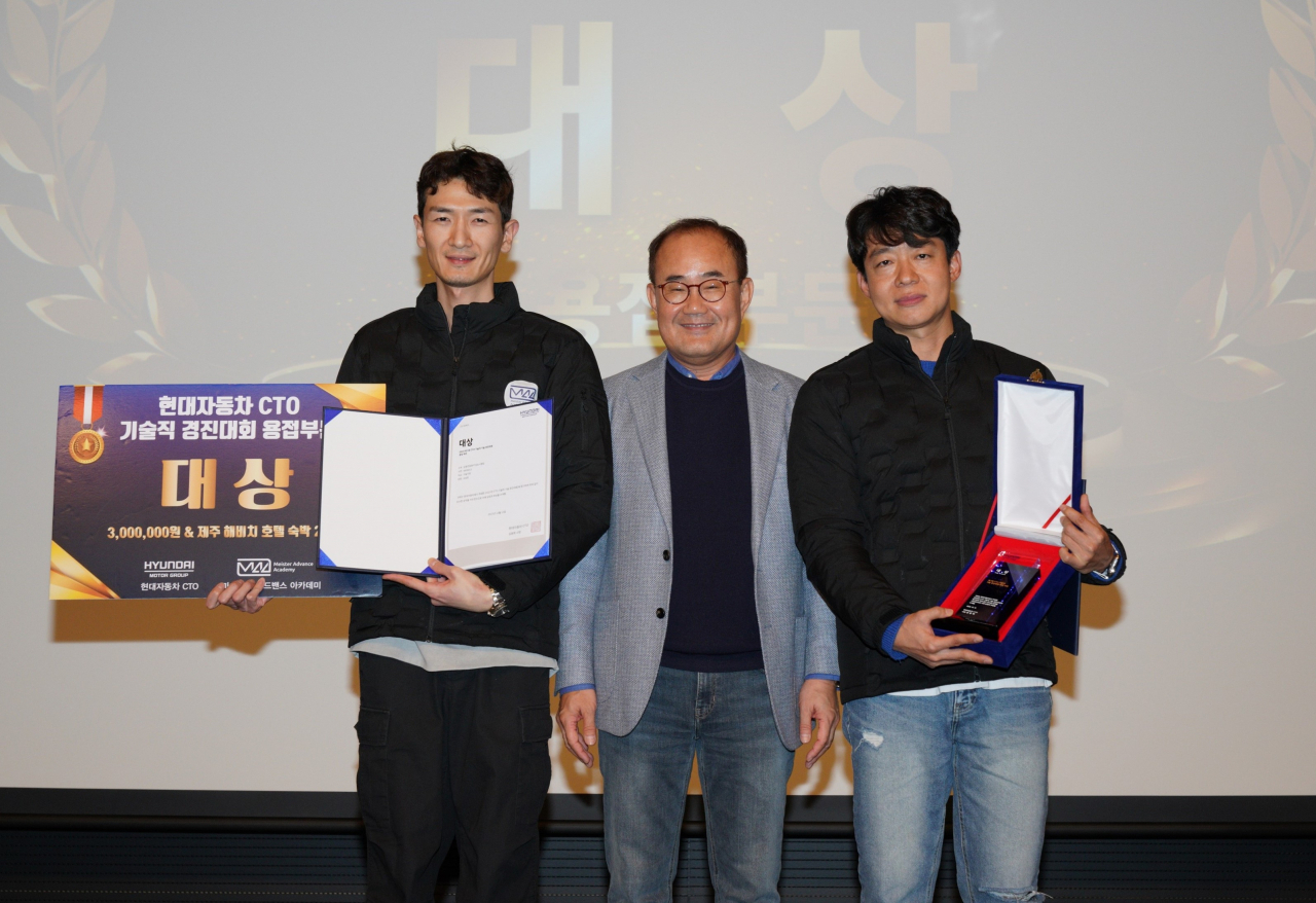 지난 12일 경기 화성에서 열린 현대차·기아 연구개발 기술직군 대상 경진대회에서 김용화(가운데) 현대차·기아 CTO 사장이 용접 분야 1등팀 오승한 기술사원(왼쪽)과 김태형 기술기사보(오른쪽)에 포상한 뒤 기념 촬영을 하고 있다. [현대차·기아 제공]
