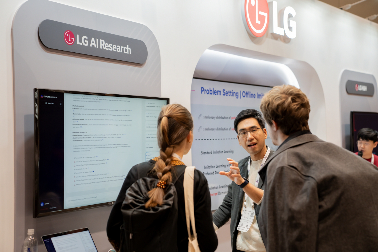 이문태(가운데) LG AI연구원 어드밴스드 ML랩장이 미국 뉴올리언스에서 열린 세계 최대 머신러닝 학회 ‘뉴립스 2023’에서 LG 통합 부스를 찾은 AI 연구자들과 대화를 나누고 있다. [LG 제공]