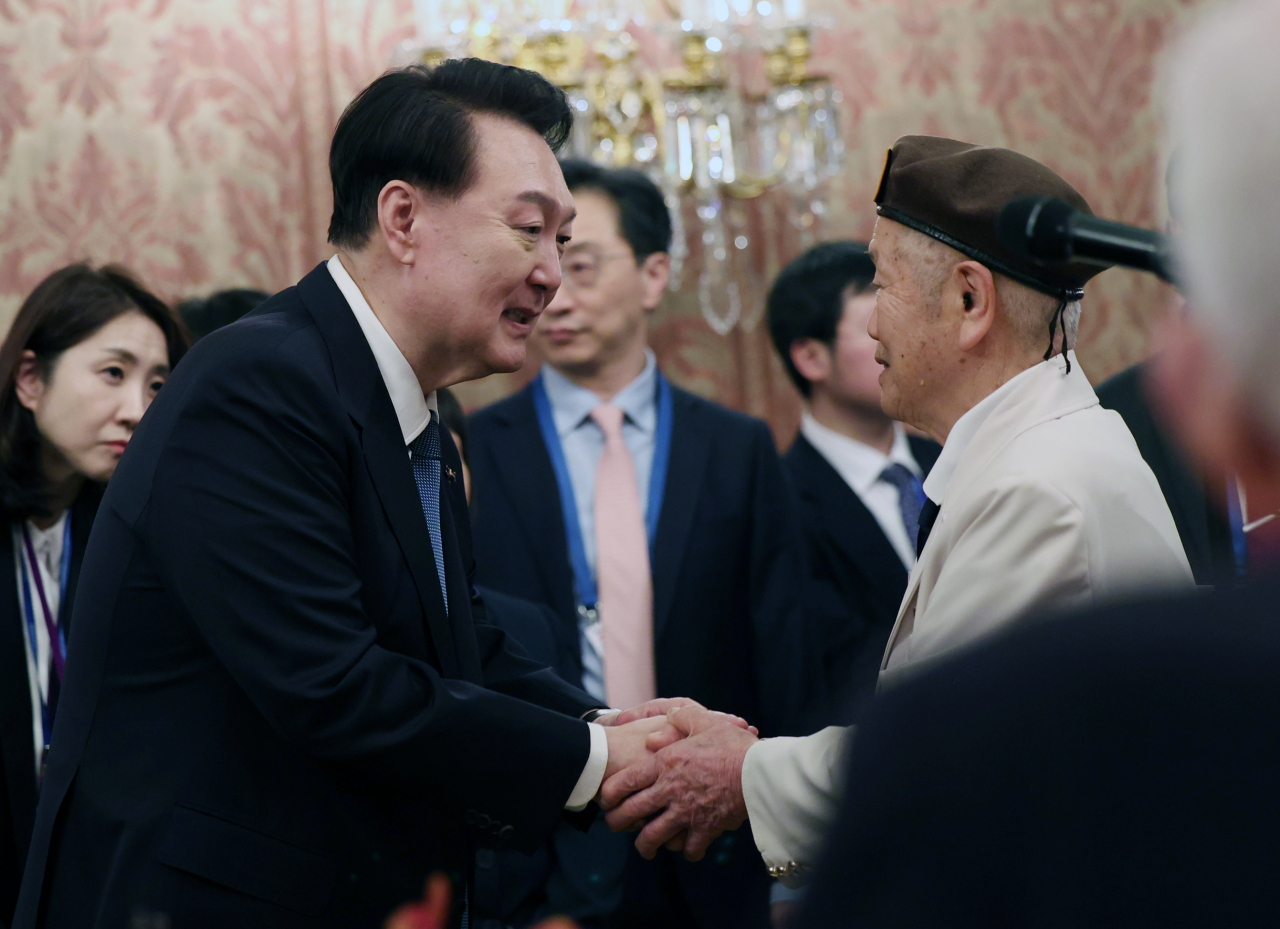 네덜란드를 국빈 방문한 윤석열 대통령이 13일(현지시간) 암스테르담 왕궁에서 열린 네덜란드 한국전 참전 용사·유가족 간담회에서 참전용사 최병수 씨와 악수하고 있다. 연합뉴스