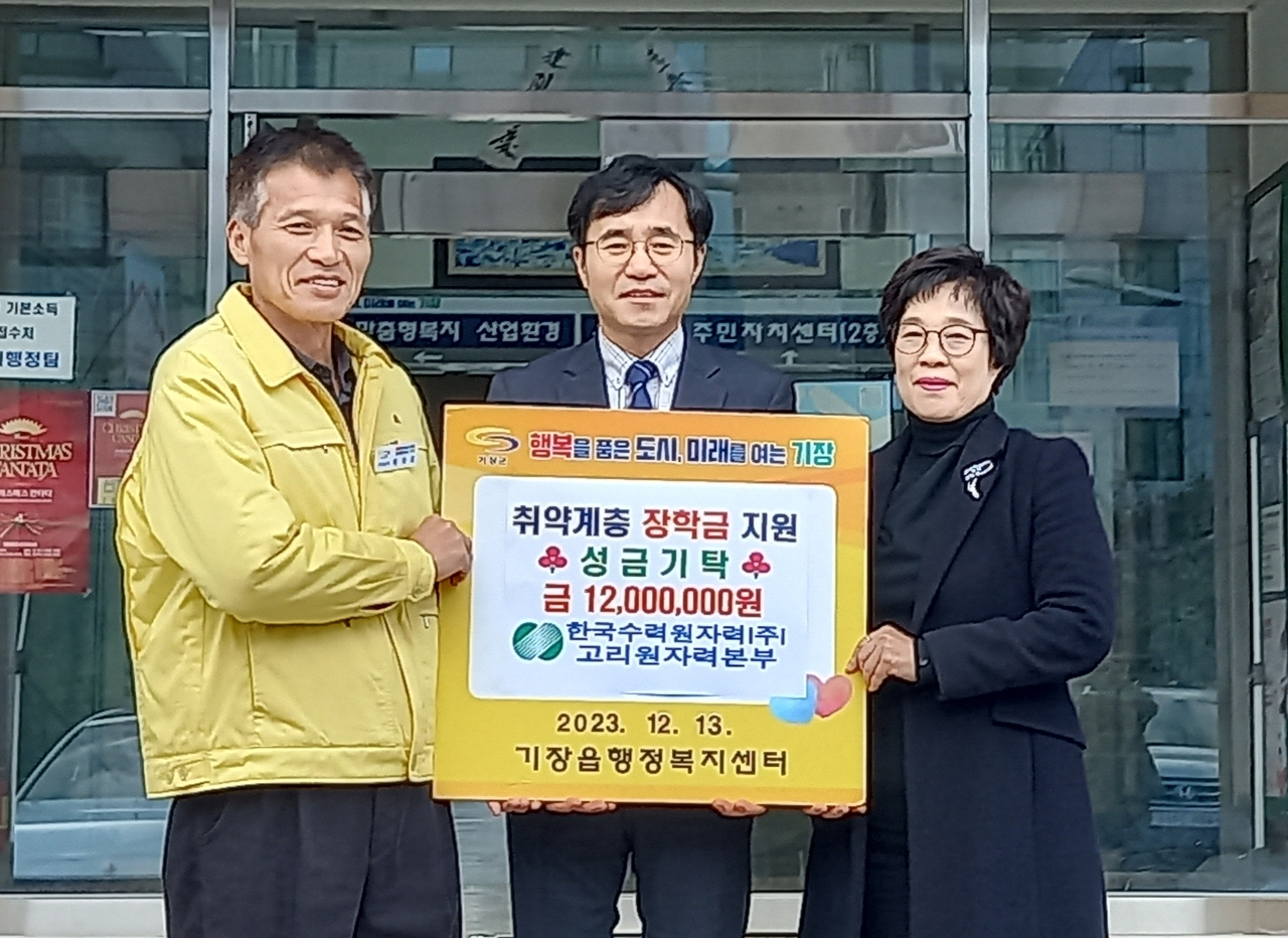 정재락 한수원 고리원자력본부 대외협력처장(가운데)이 기장군 기장읍지역사회보장협의체와 함께 장학금을 전달식을 진행하고 있다. [사진=기장군]