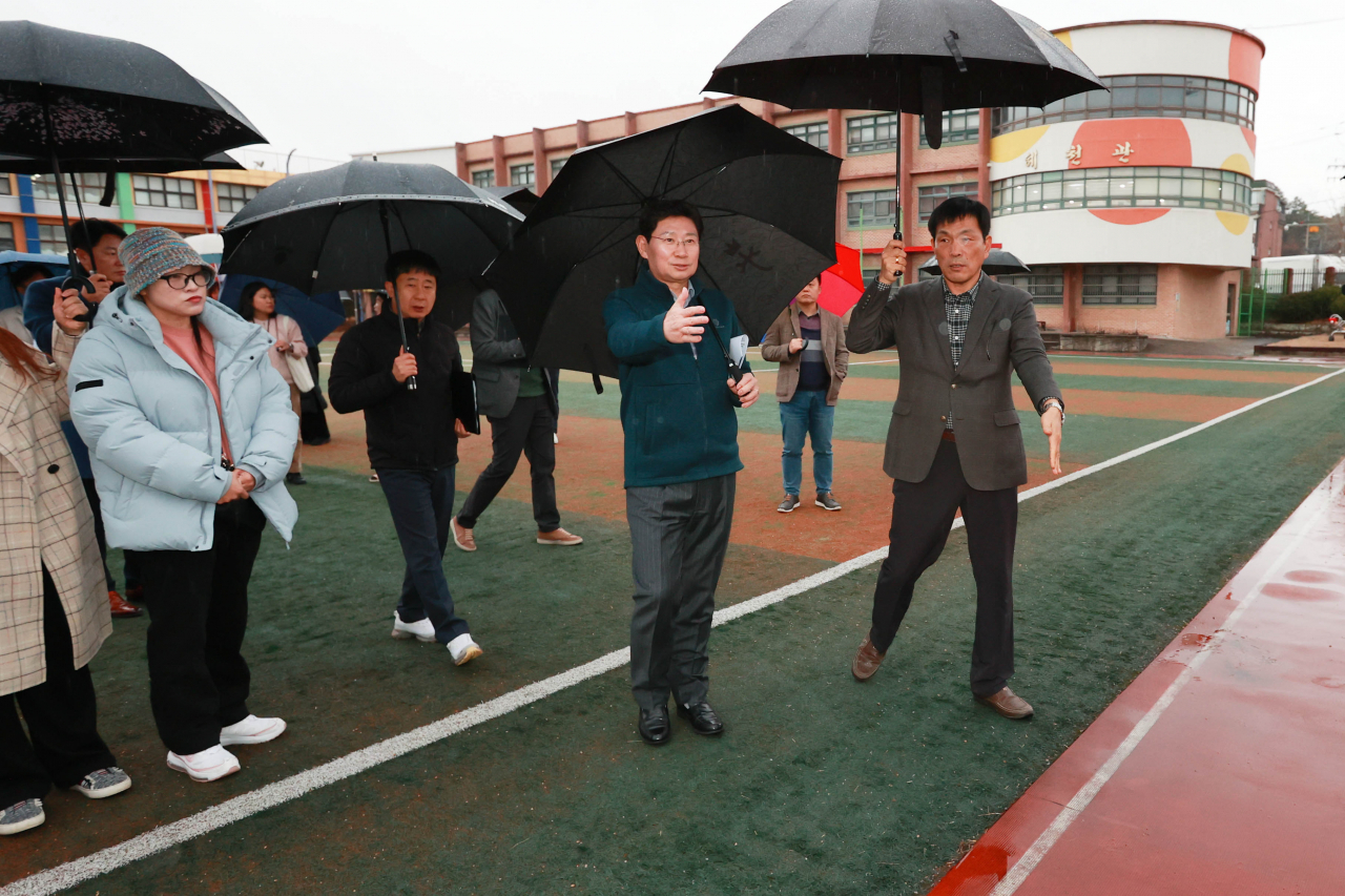 이상일 용인특례시장이 지난 14일 용천초등학교를 방문해 수영장 건립 부지를 확인하고 학교 관계자들과 의견을 나누고 있다.[용인시 제공]