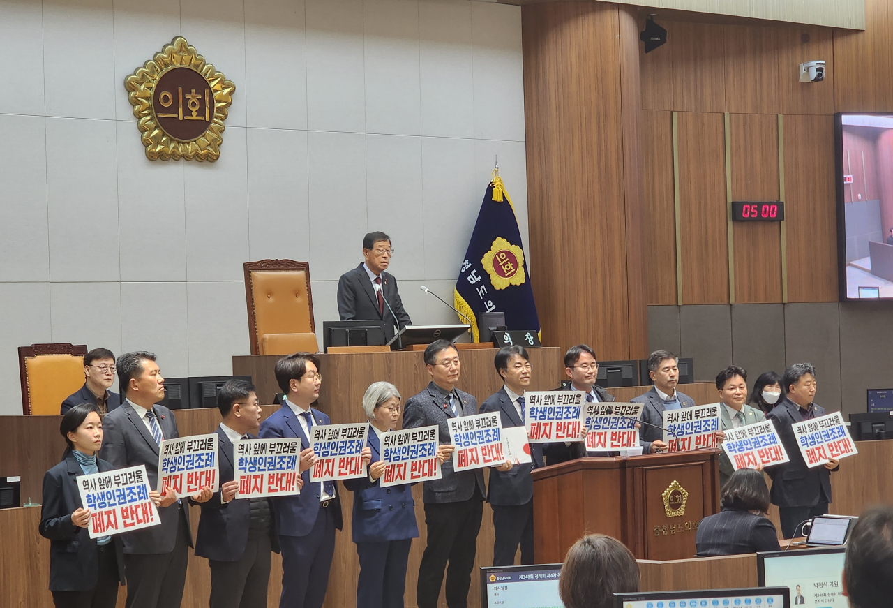 충남학생인권조례 폐지안 처리가 예정된 15일 충남도의회 제348회 정례회 제4차 본회의에 앞서 더불어민주당 도의원들이 '역사 앞에 부끄러울 학생인권조례 폐지 반대'라는 손팻말을 들고 서 있다. 연합뉴스