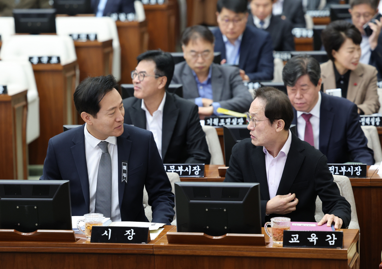 오세훈 서울시장과 조희연 서울시 교육감이 지난달 16일 서울시의회 본회의장에서 열린 본회의에 참석해 대화하고 있다.[연합]