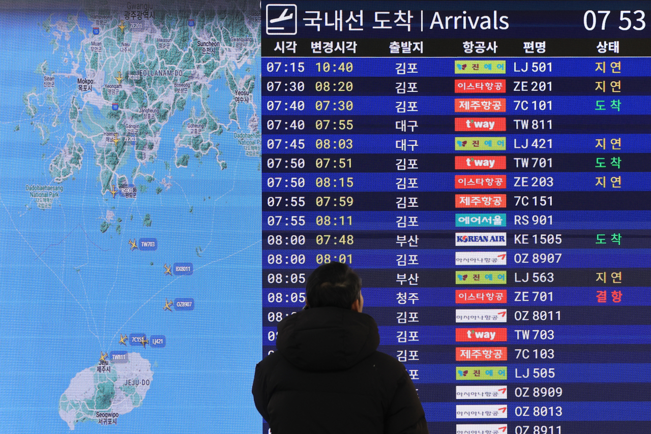 전국에 한파가 몰아친 17일 제주국제공항 도착층에서 한 이용객이 국내선 도착 전광판을 살펴보고 있다. [연합]