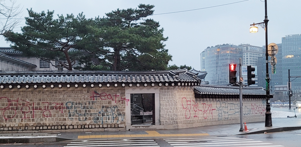 16일 오전 서울 종로구 국립고궁박물관 방향 경복궁 서쪽 담장에 붉은색과 푸른색 스프레이로 ‘영화공짜’라고 쓴 낙서가 적혀있다. [연합]