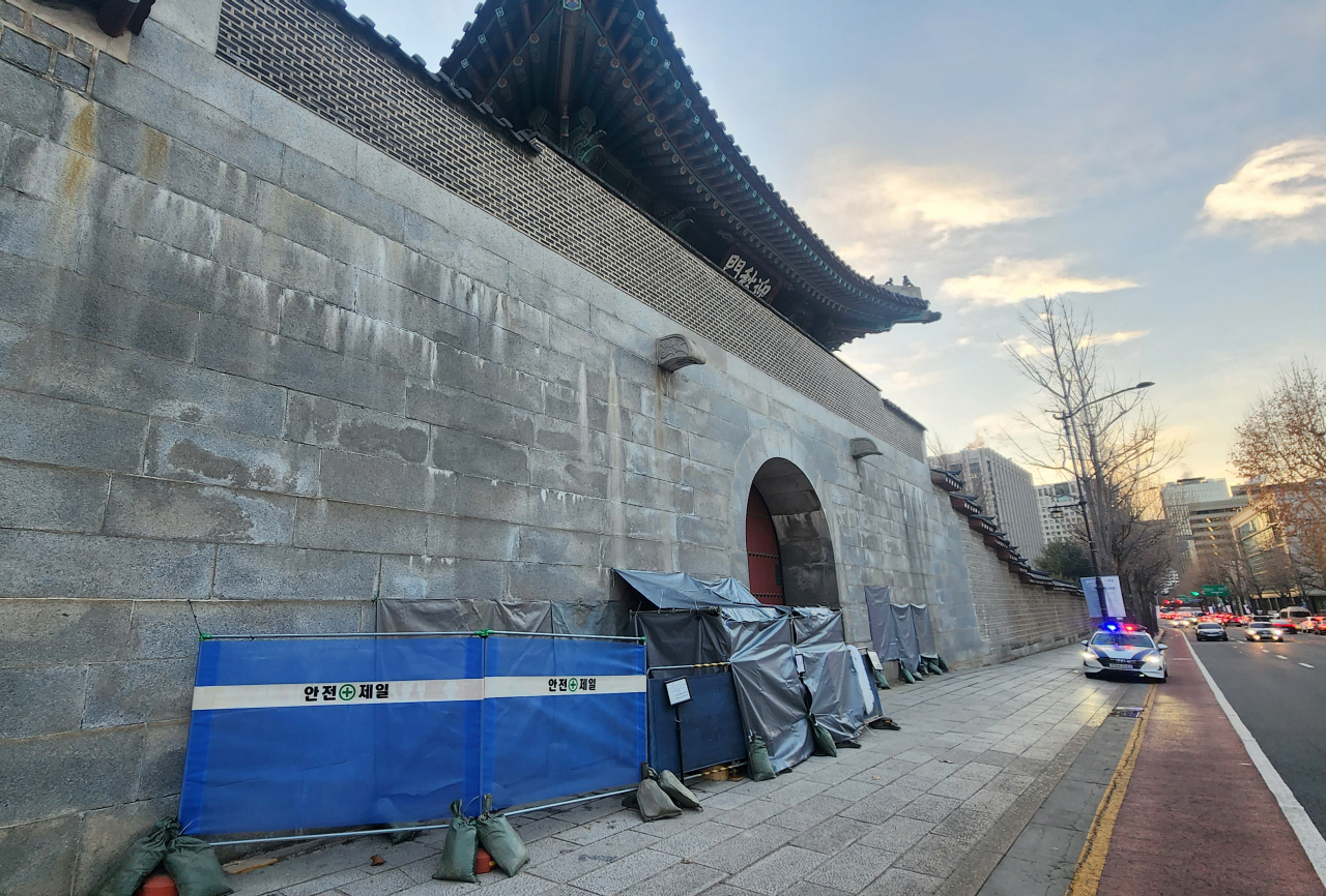 서울 경복궁 담벼락이 스프레이 낙서로 훼손된 지 하루 만에 또다시 낙서 테러를 당한 가운데 18일 오전 새 낙서가 발견된 서울 경복궁 영추문 담벼락에 (왼쪽) 가림막이 설치돼 있다. 새로운 낙서가 발견된 곳은 영추문 낙서 제거 작업 현장 바로 옆으로 낙서는 영문으로 쓰인 것으로 알려졌다. [연합]