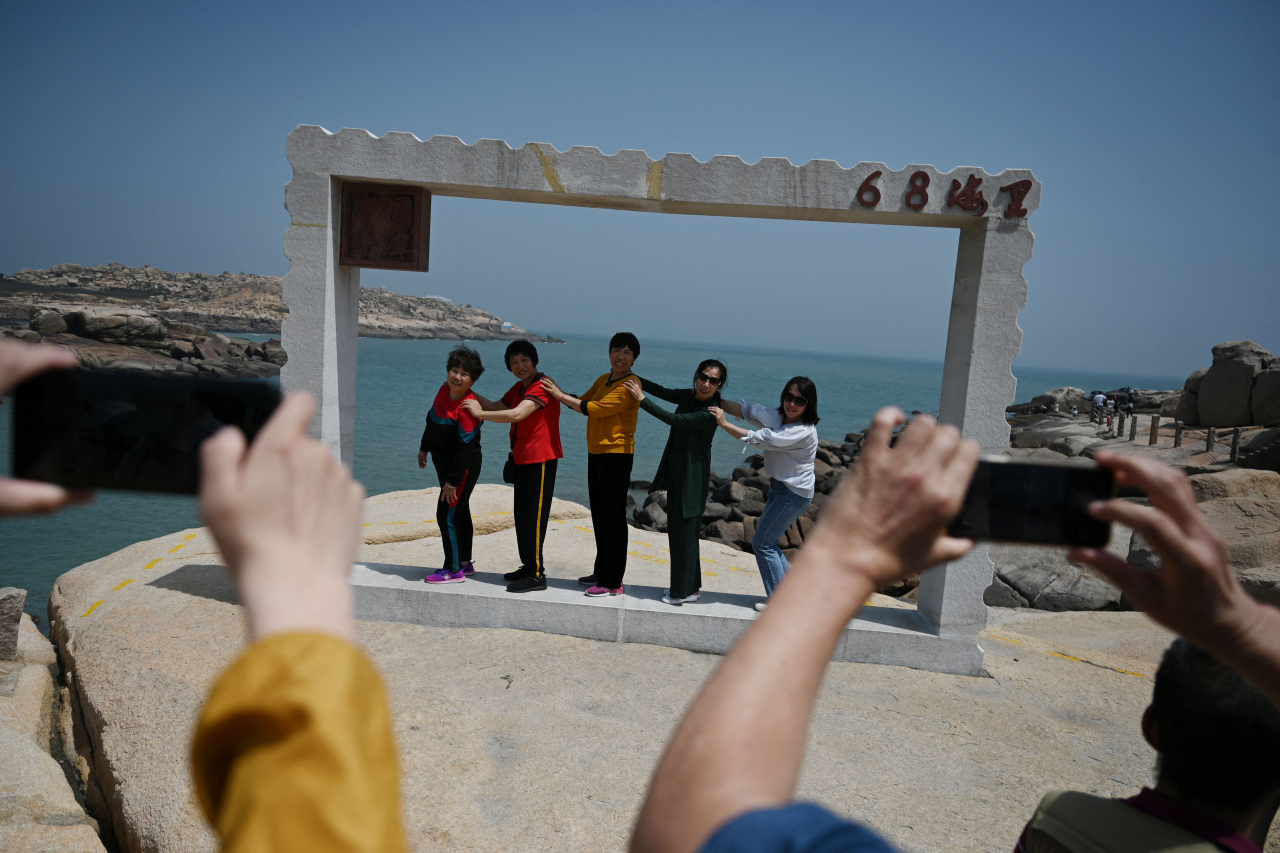 지난 4월 중국 푸젠성 남동부 핑탄섬 해안에서 중국 관광객들이 기념 촬영을 하고 있다. [AFP]