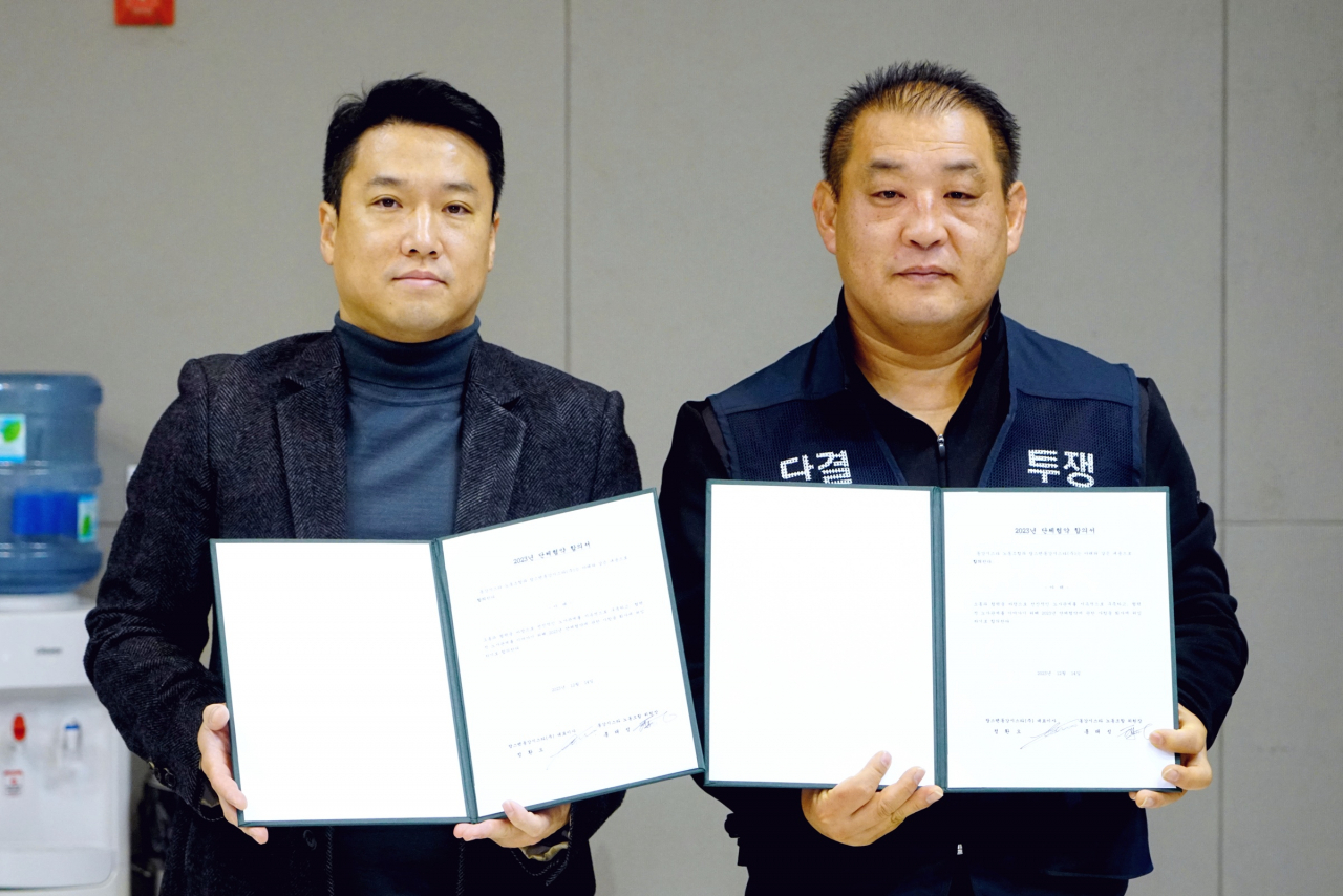 정환오(왼쪽) SM그룹 탑스텐리조트 동강시스타 대표이사와 홍태성 동강시스타 노조위원장이 단체협약 합의서를 들고 기념 촬영을 하는 모습. [탑스텐리조트 동강시스타 제공]