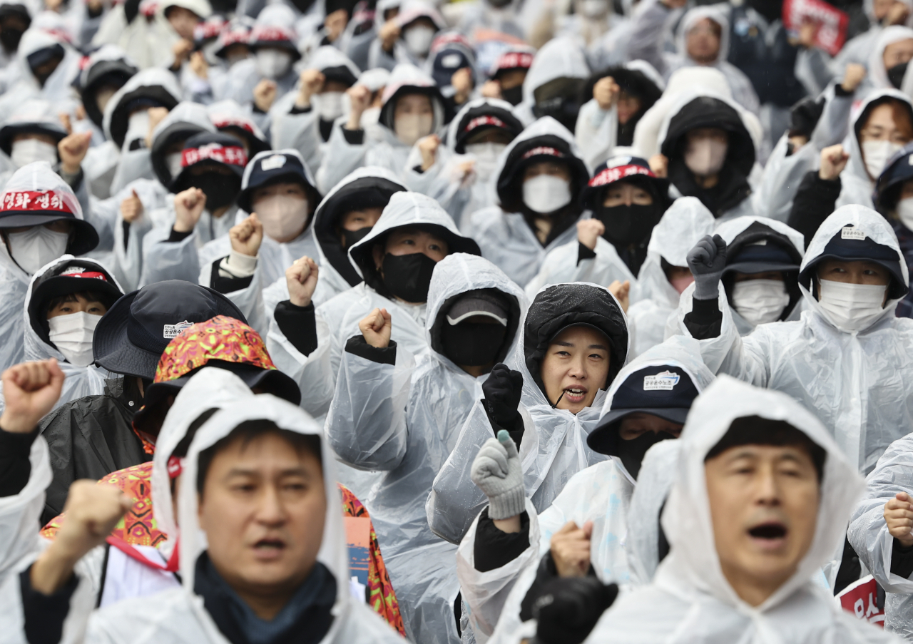 지난 14일 서울역 인근에서 열린 민주노총 결의대회에 참석한 조합원들이 민중의례를 하고 있다. [연합]