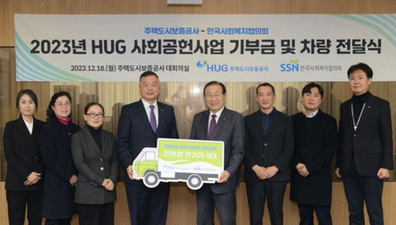 12월 18일 ‘HUG 드림카’ 사업 차량 기증식 현장에서 유병태 HUG 사장(왼쪽에서 4번째)과 관계자들이 기념 촬영을 하고 있다. [주택도시보증공사]