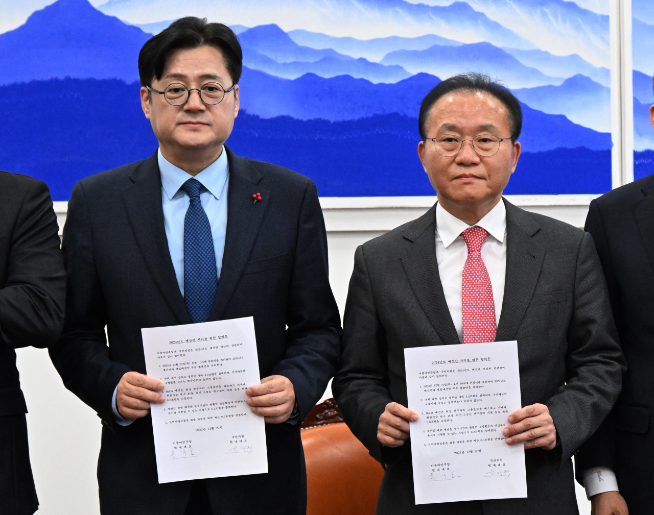 윤재옥 국민의힘 당 대표 권한대행 겸 원내대표와 홍익표 더불어민주당 원내대표가 20일 국회에서 2024년도 예산안 처리를 위한 합의를 마친 뒤 합의문을 들어보이고 있다. [연합]