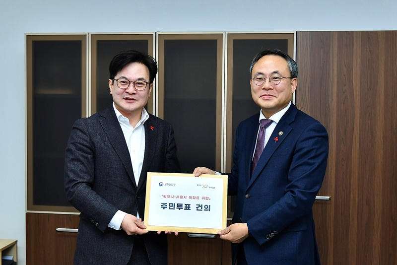 김병수 김포시장〈왼쪽〉이 20일 고기동 행정안전부 차관에게 ‘김포-서울 통합’을 위한 주민투표 건의문을 전달했다.〈김포시 제공〉