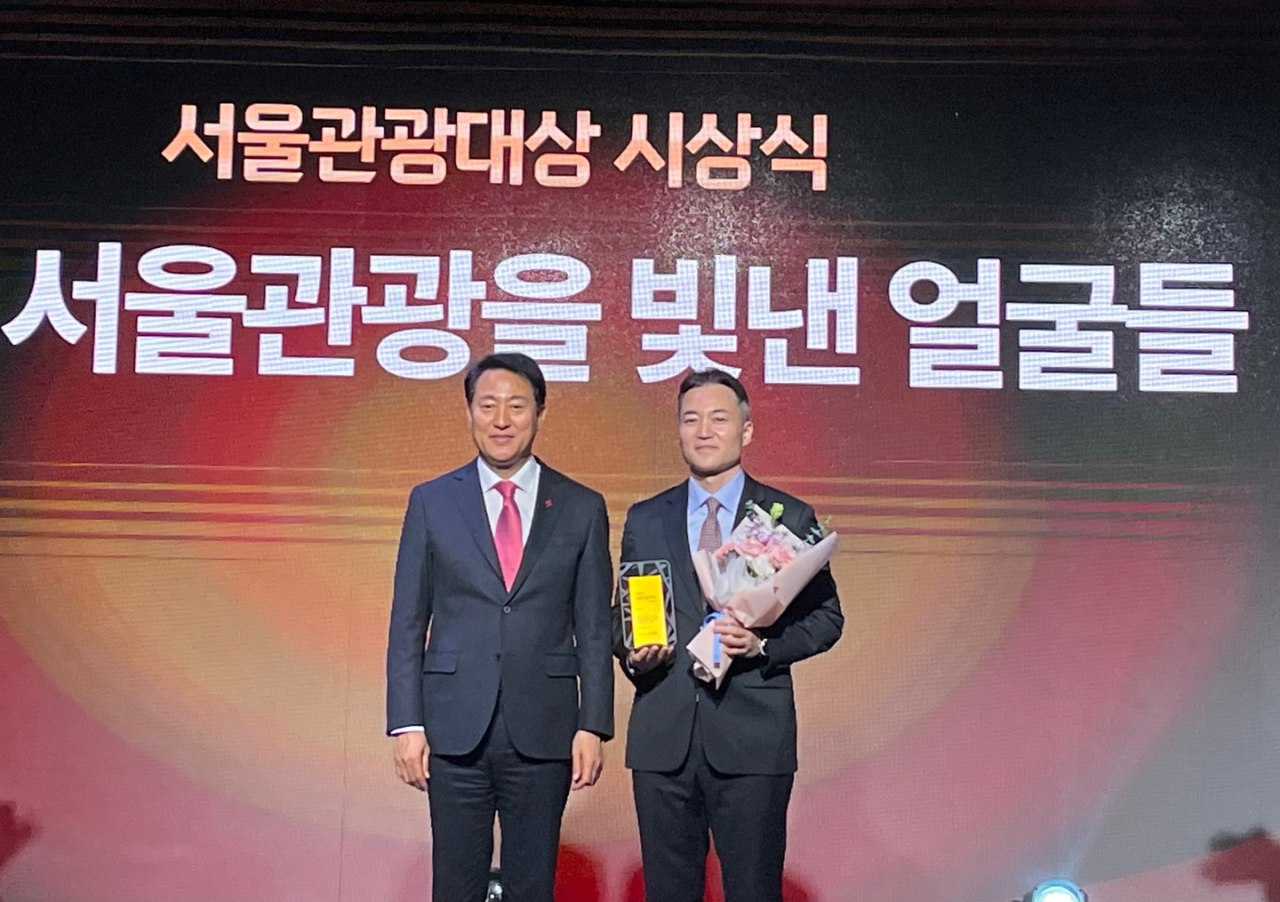 홍종민(오른쪽) 트립닷컴 한국지사장이 상을 받은 뒤 오세훈 시장과 기념촬영을 하고 있다.