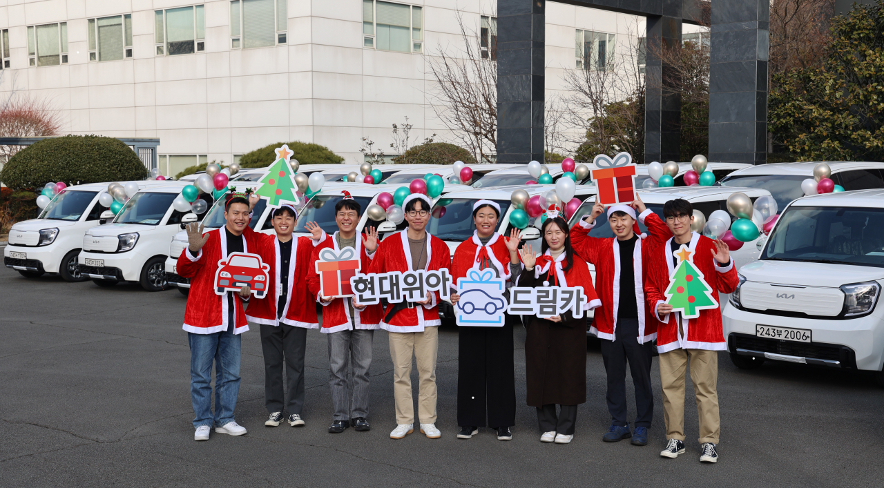 현대위아 직원들이 21일 경상남도 창원시 현대위아 본사 앞에서 지역 사회복지기관 20곳에 선물할 ‘현대위아 드림카’와 함께 기념 사진을 찍고 있다. [현대위아 제공]