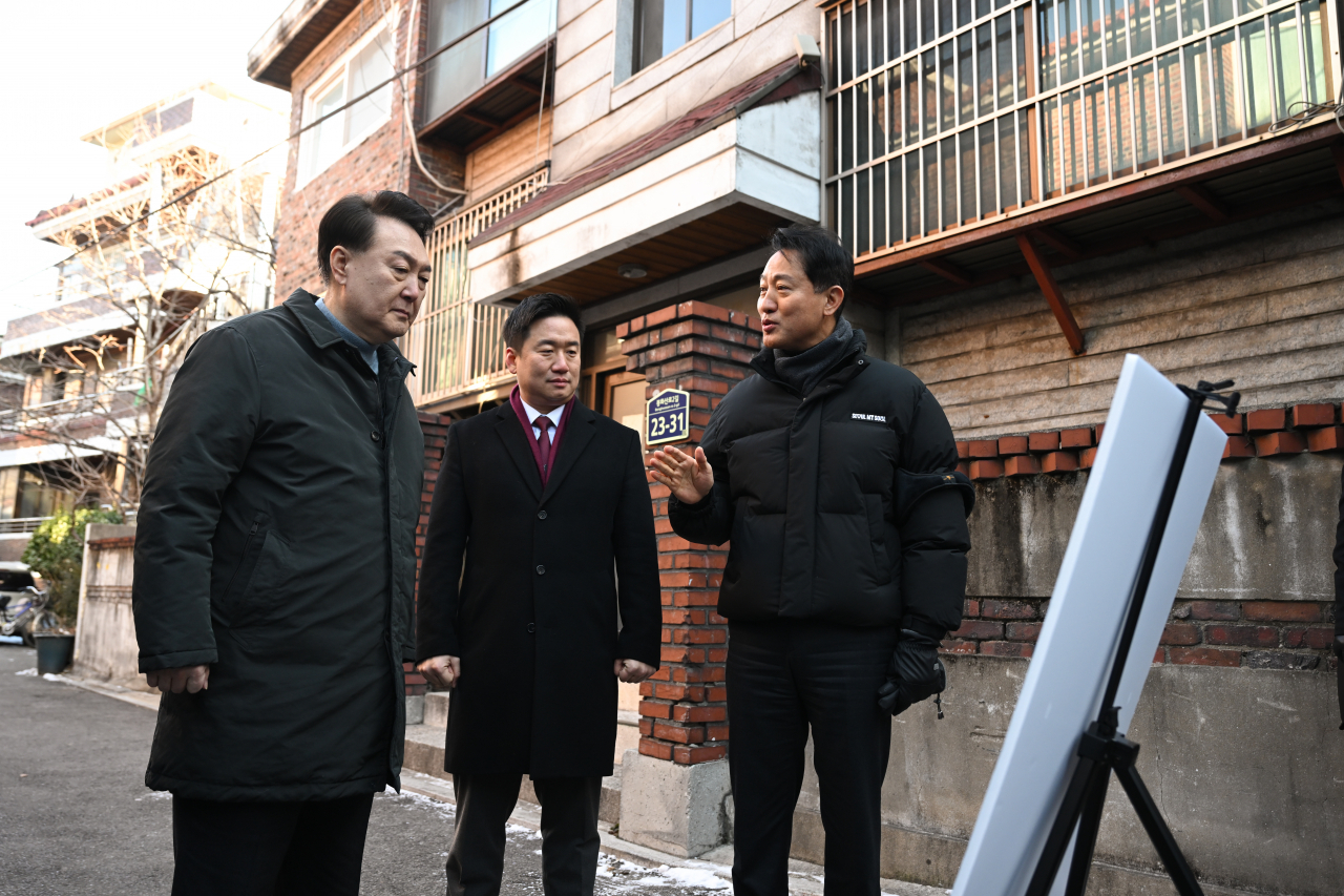 윤석열 대통령이 21일 서울 중랑구의 소규모주택정비 관리지역인 모아타운 사업지를 방문해 오세훈 서울시장으로부터 현장에 대한 설명을 듣고 있다. [연합]