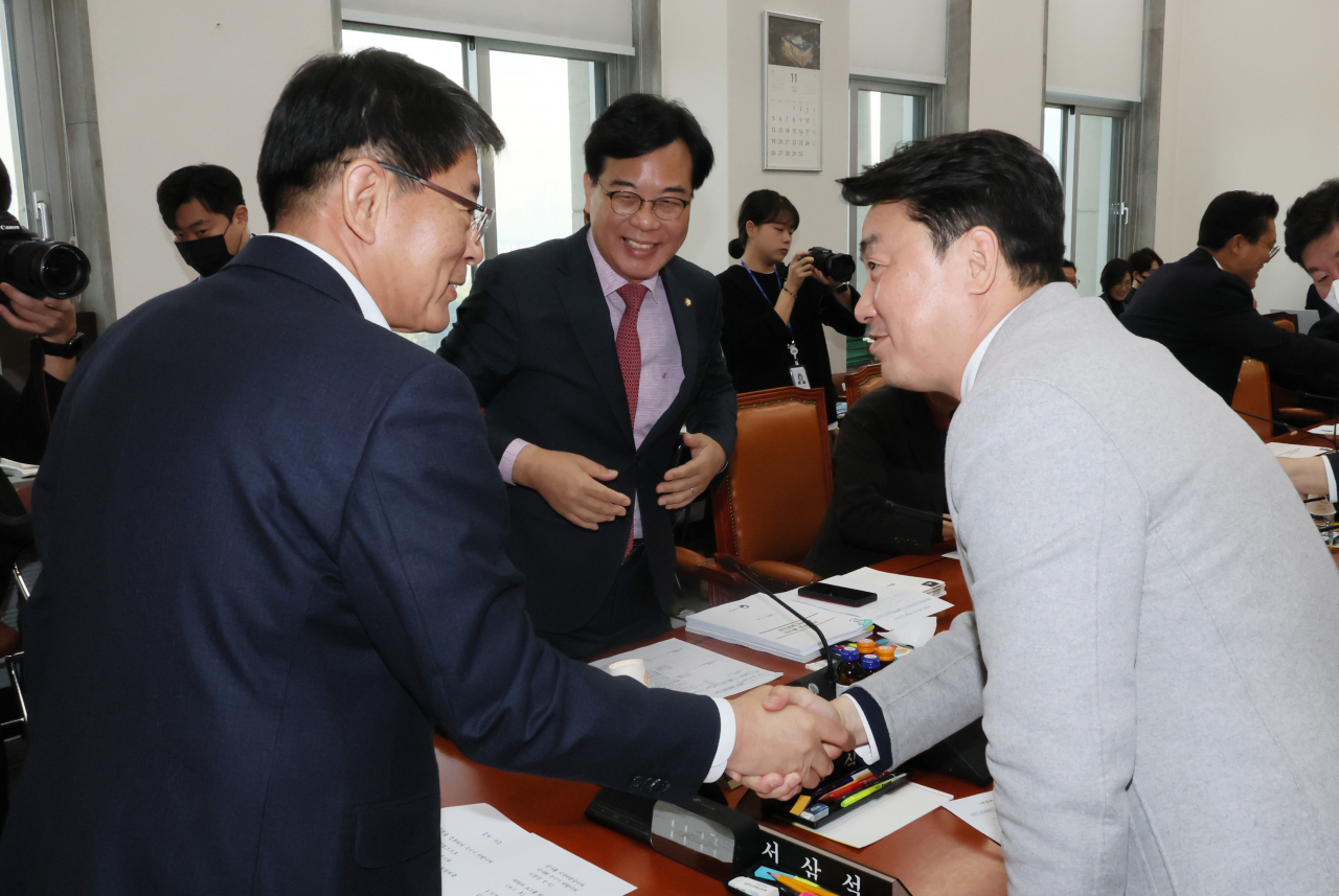 국회 예산결산특별위원회 예산심사소위에서 서삼석 위원장과 더불어민주당 강훈식 의원이 악수하고 있다. 가운데는 송언석 의원. [연합]