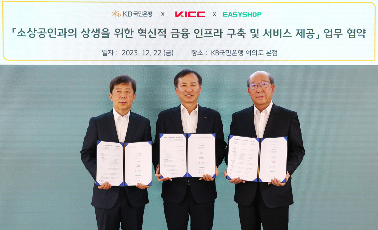 22일 서울 영등포구에 위치한 KB국민은행 본점에서 진행된 ‘소상공인과의 상생을 위한 혁신적 금융 인프라 구축 및 서비스 제공’ 업무 협약식에서 임명수(왼쪽에서 세번째) 한국정보통신 대표이사, 강의중(왼쪽에서 첫번째) 이지샵 대표이사, 정문철 KB국민은행 개인고객그룹 대표가 기념 사진을 촬영하고 있다.[KB국민은행 제공]