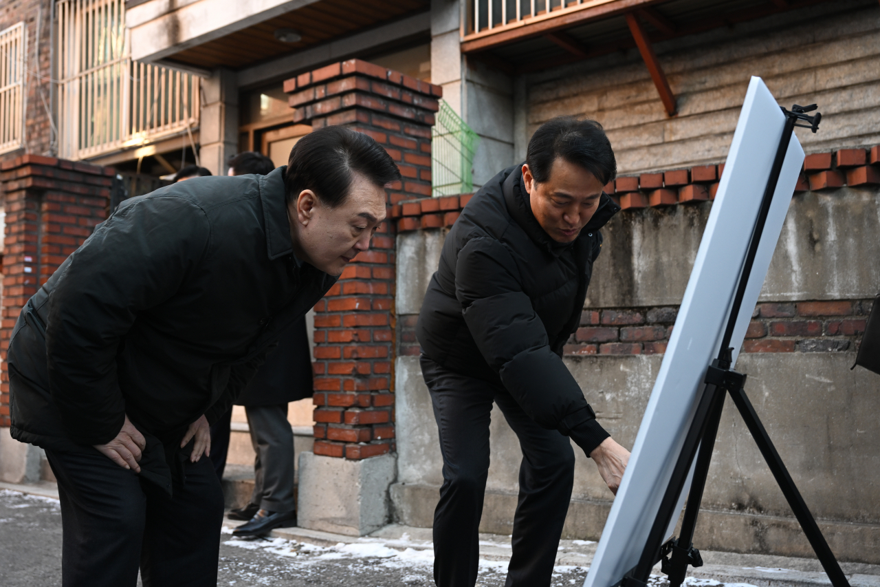 윤석열 대통령이 21일 서울 중랑구의 소규모주택정비 관리지역인 모아타운 사업지를 방문해 오세훈 서울시장으로부터 현장 설명을 듣고 있다.[연합]