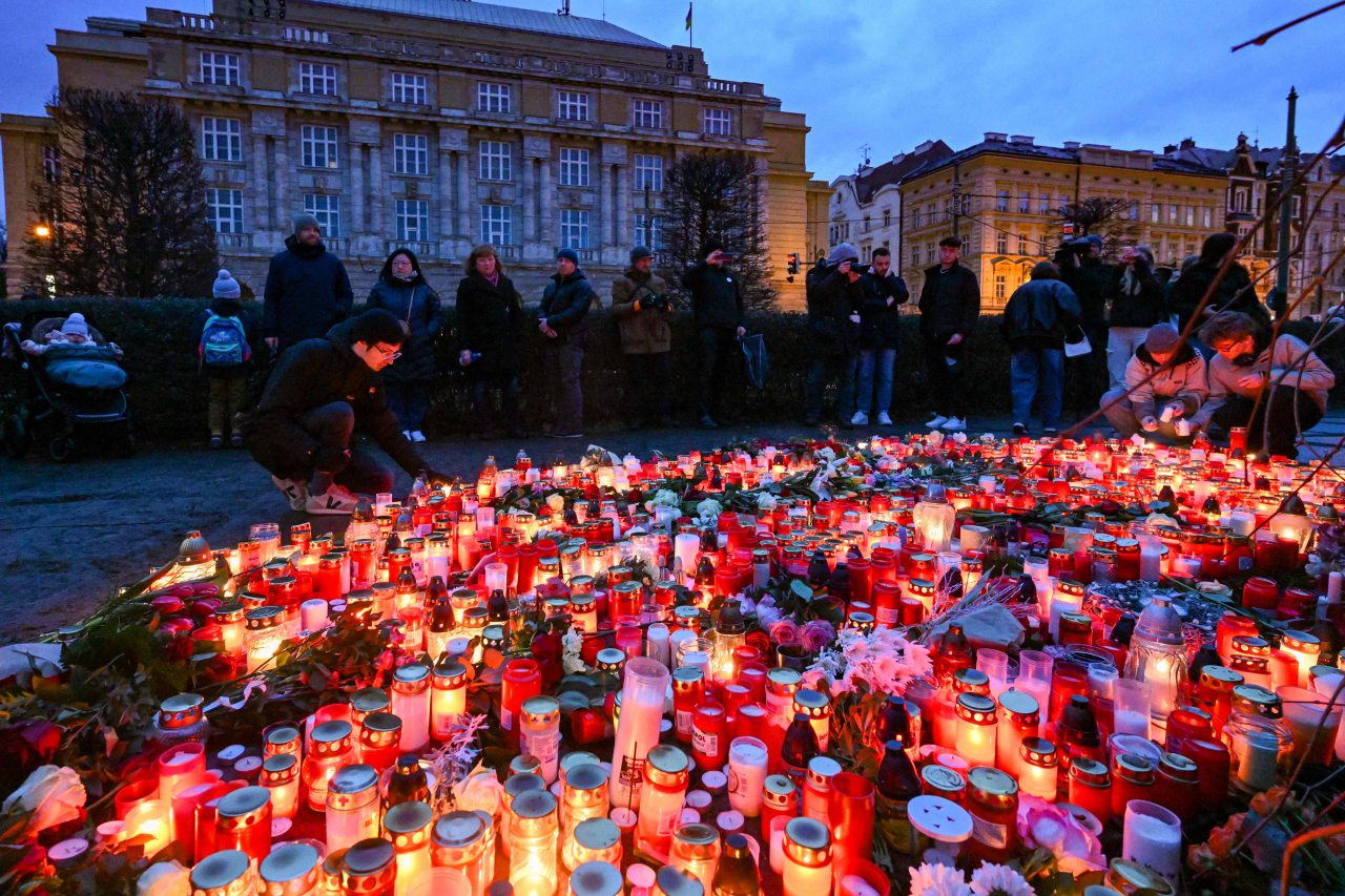 People mourn at a makeshift memorial for the victims outside the Charles University in central Prague, on December 22, 2023, as police investigators kept working on the campus the day after a deadly mass shooting. (Michal Cizek / AFP)