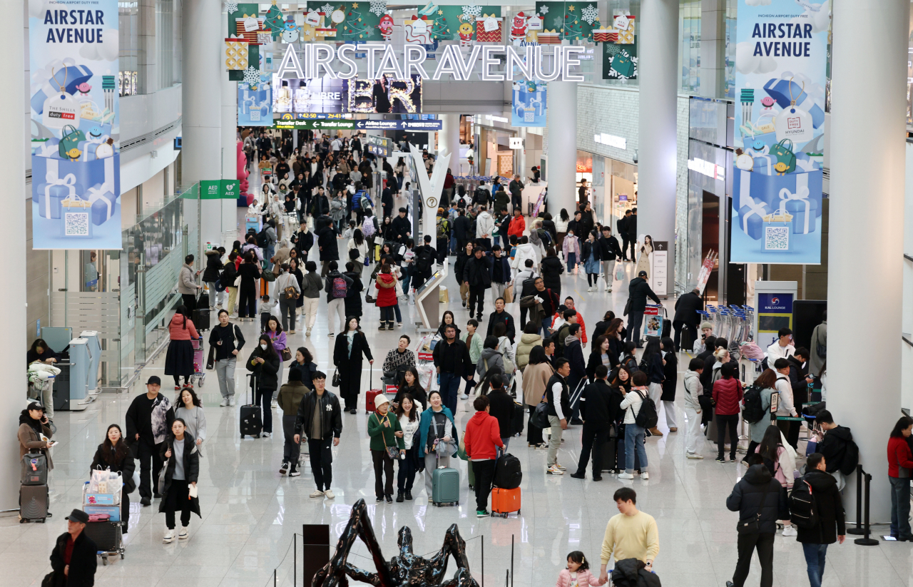 Incheon International Airport bustles with travelers ahead of the Christmas holiday on Friday. (Yonhap)