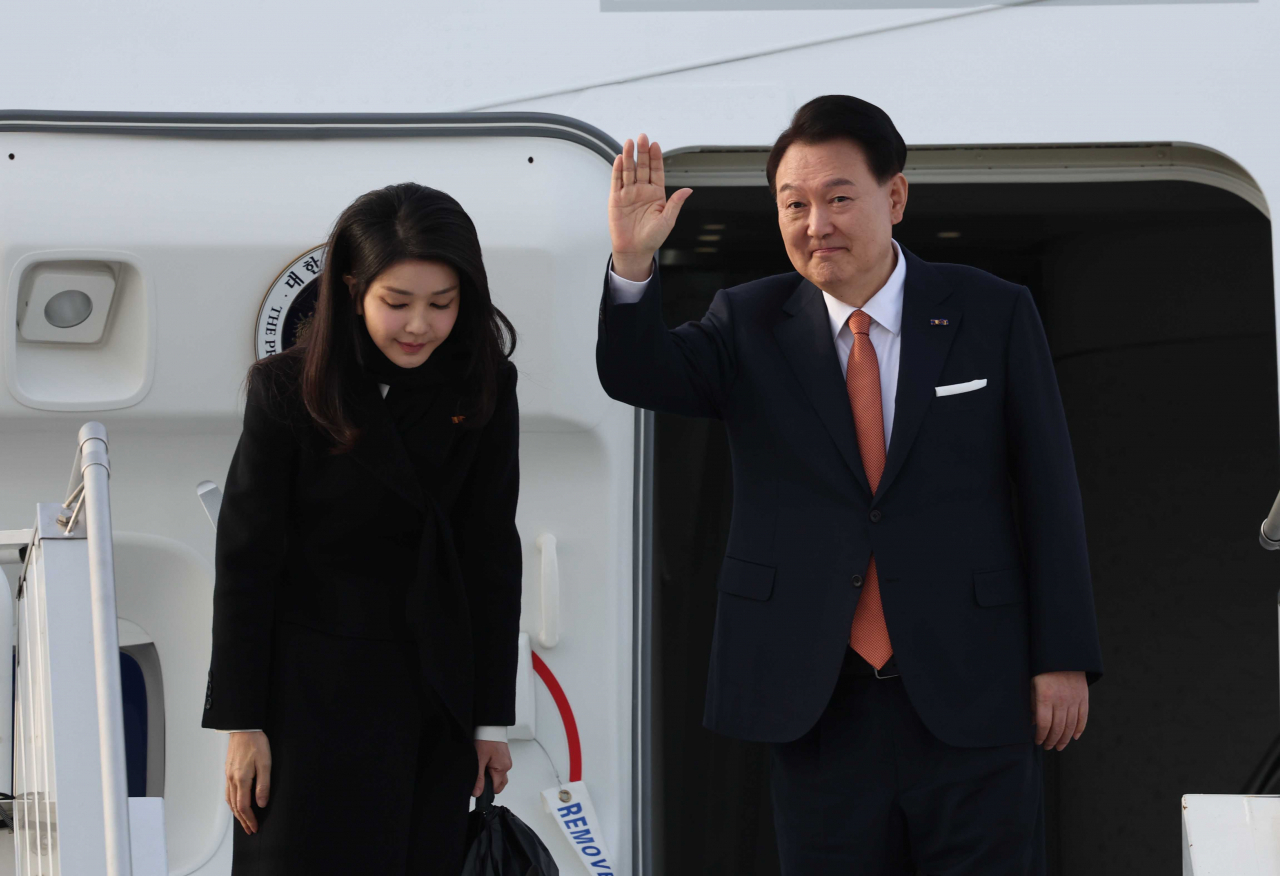 네덜란드 국빈 방문 일정을 마친 윤석열 대통령과 부인 김건희 여사가 지난해 12월 14일(현지시간) 암스테르담 스히폴 공항에서 귀국하기 전 전용기인 공군 1호기에서 손들어 인사하고 있다. [연합]