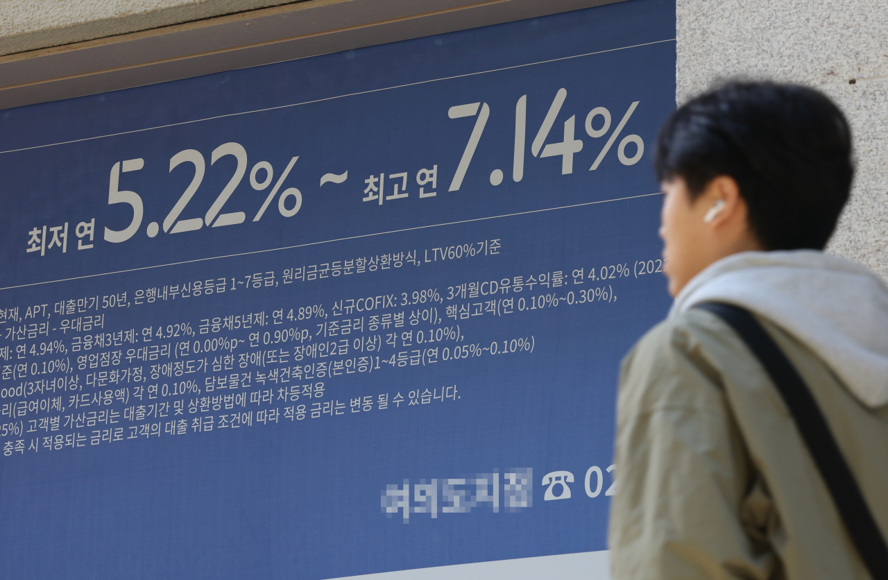 서울 한 시중은행 영업점의 대출 안내문 앞을 시민이 지나가고 있다.[연합]