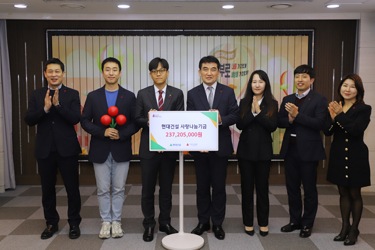 현대건설 사원협의체 위원과 사회복지공동모금회 황인식 사무총장(오른쪽에서 네 번째)이 사랑나눔기금 전달식을 진행하고 있다. [현대건설 제공]
