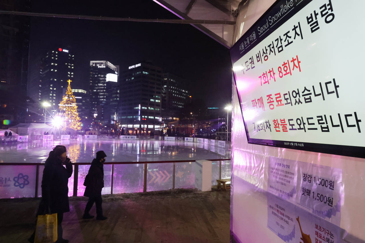 27일 밤 서울광장 스케이트장을 찾은 시민과 관광객들이 수도권 비상 저감조치 발령 안내문을 보고 아쉬운 발길을 돌리고 있다. 서울시는 27일 오후 5시를 기해 서울지역에 미세먼지 비상저감조치가 발령됨에 따라 이용객의 건강과 안전을 위해 서울광장 스케이트장 운영을 중단한다고 밝혔다. [연합]