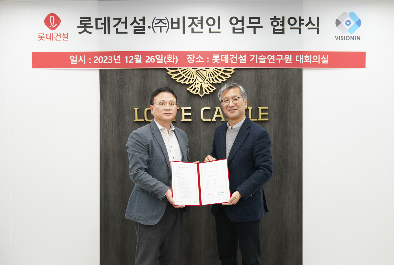 석원균 롯데건설 기술연구원장(왼쪽)과 김학일 비젼인 대표(오른쪽)가 업무협약 후 기념사진을 촬영하고 있다. [롯데건설 제공]