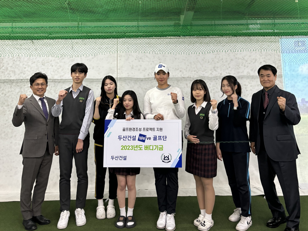 오세욱 두산건설 상무(왼쪽 첫번째), 두산건설 We’ve 골프단 김민솔 선수(왼쪽 다섯번째), 김팔성 강북중학교 교장(왼쪽 여덟번째)를 비롯해 강북중학교 학생들이 기념사진을 촬영했다. [두산건설 제공]