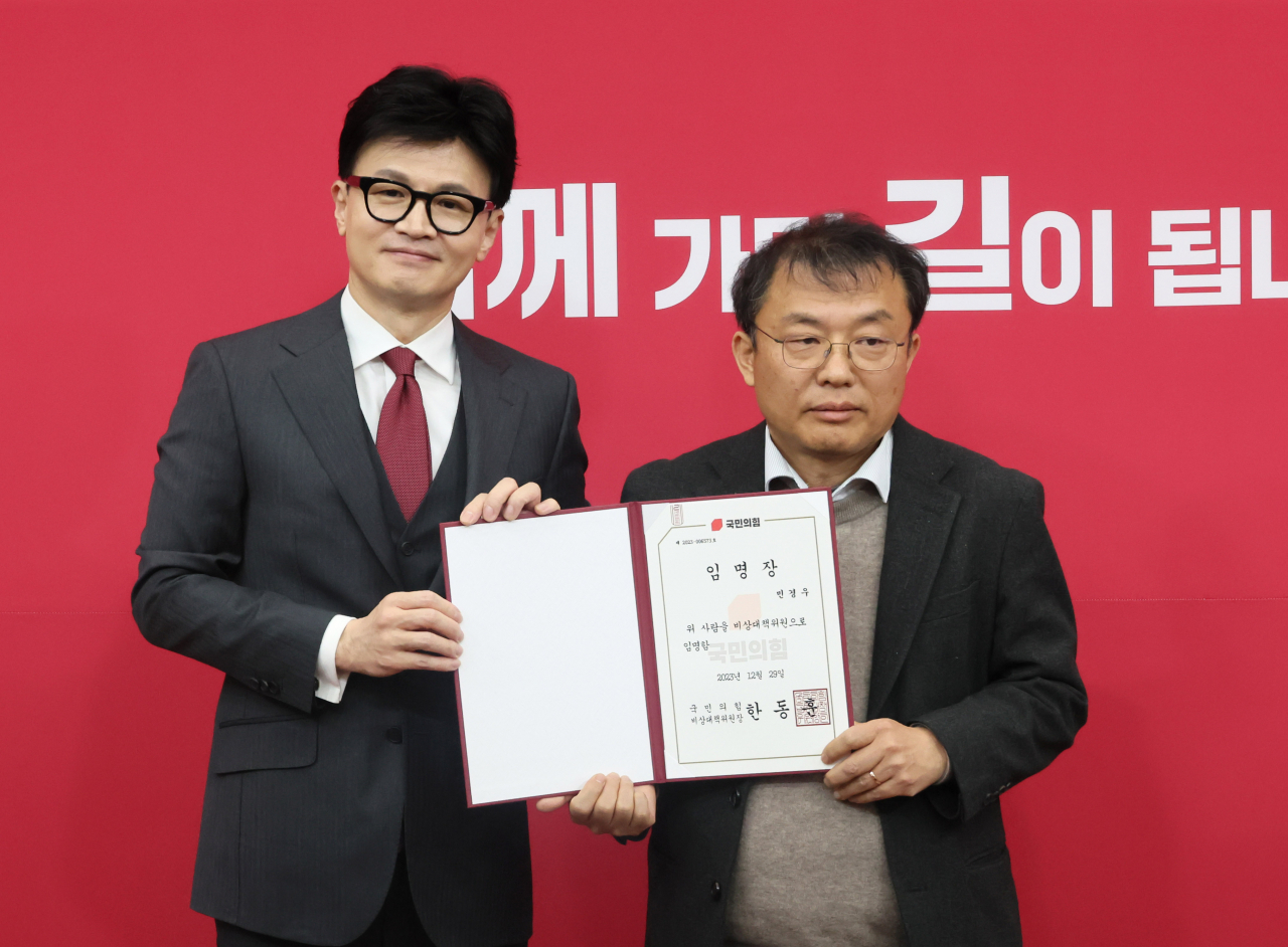 국민의힘 한동훈 비상대책위원장이 29일 국회에서 열린 비상대책위원 임명장 수여식에서 민경우 비대위원에게 임명장을 수여한 뒤 포즈를 취하고 있다. [연합]