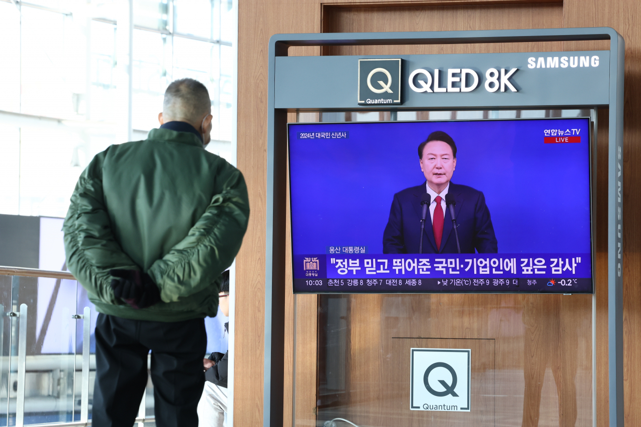 새해 첫날인 1일 오전 서울역 대합실에서 한 시민이 윤석열 대통령의 2024년 신년사 방송을 지켜보고 있다. [연합]