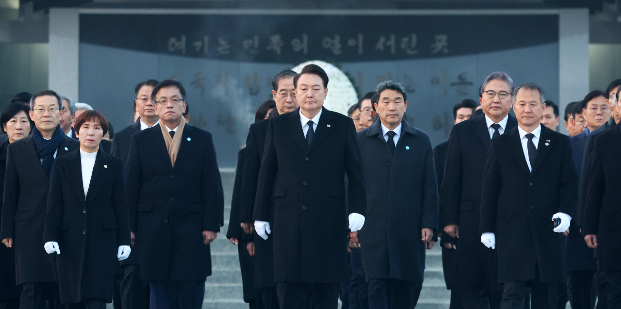 윤석열 대통령이 2024년 새해 첫날인 1일 서울 동작구 국립서울현충원에서 국무위원 및 참모진과 함께 현충탑에 참배한 뒤 걸어나오고 있다. [연합]