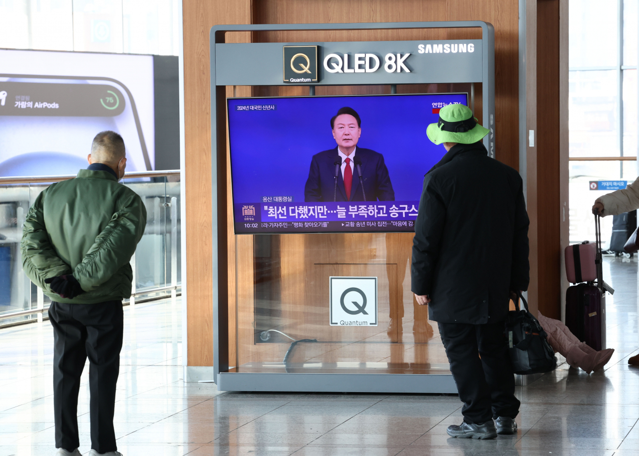 2024년 새해 첫날인 1일 서울역 대합실에서 시민들이 윤석열 대통령의 2024년 신년사 방송을 지켜보고 있다. [연합]