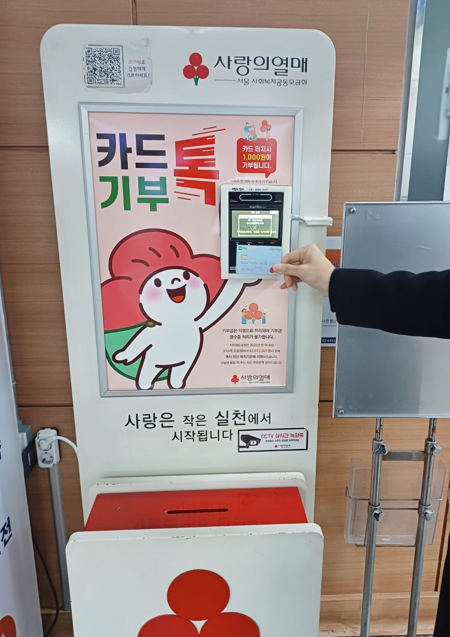 한 시민이 서울 사랑의열매 지하철모금함 간편 기부 단말기에 카드를 태그해 기부에 참여하고 있다.