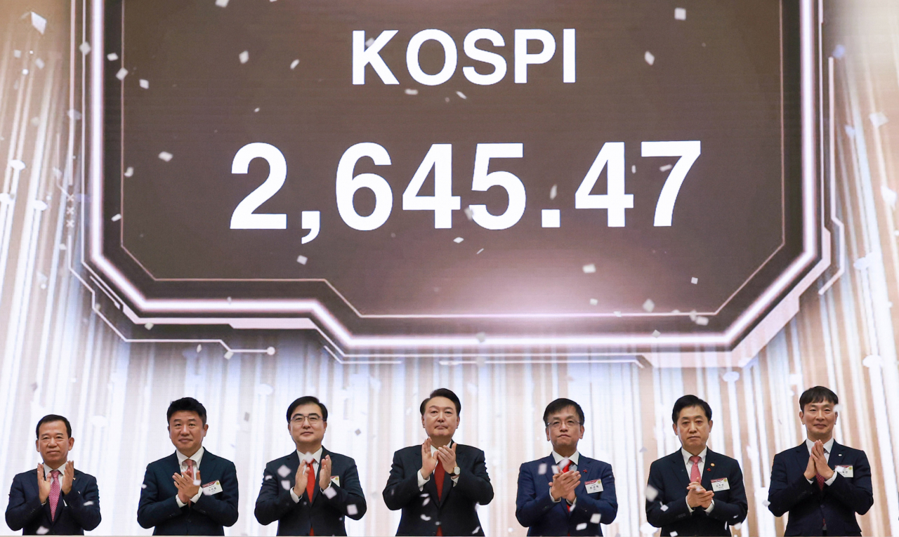 윤석열 대통령이 현직 대통령으로서는 사상 최초로 2일 오전 서울 영등포구 여의도 한국거래소에서 열린 2024 증권·파생상품시장 개장식에 참석해 개장 신호 버튼을 누른 뒤 박수치고 있다. 왼쪽부터 서유석 한국금융투자협회장, 국민의힘 유의동 정책위의장, 손병두 한국거래소 이사장, 윤 대통령, 최상목 부총리 겸 기획재정부 장관, 김주현 금융위원장, 이복현 금융감독원장. [연합]