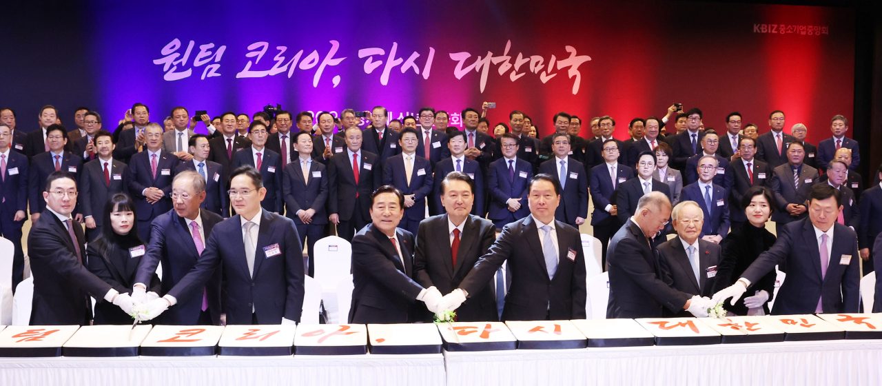 윤석열 대통령이 2일 서울 여의도 중소기업중앙회에서 열린 2024년 경제계 신년 인사회에서 경제인 단체장, 기업 회장 등과 떡케이크를 자르고 있다. [연합]
