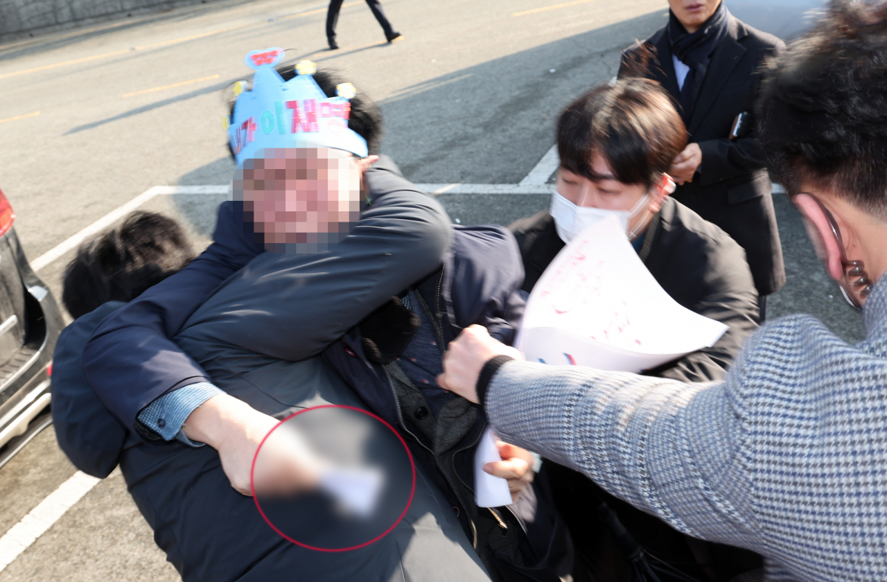 2일 오전 부산 강서구 대항전망대에서 이재명 더불어민주당 대표를 흉기로 피습한 용의자가 흉기를 든 채 경찰에 연행되고 있다. [뉴시스]